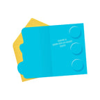 Blue card with text and circular cutouts on a yellow envelope