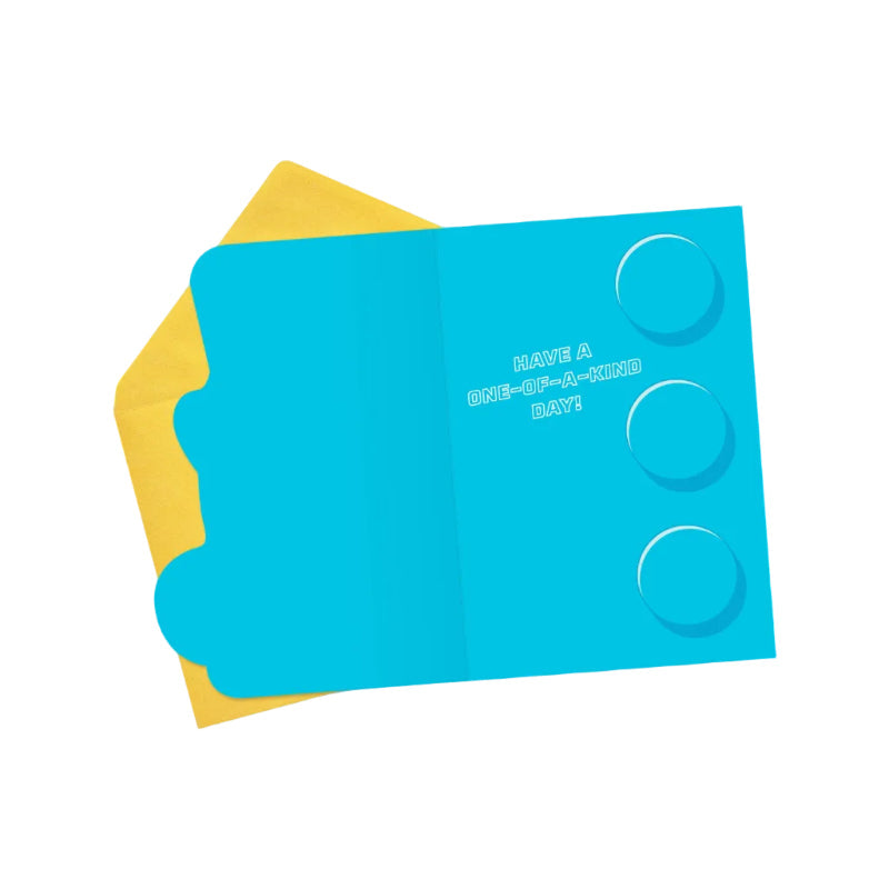 Blue card with text and circular cutouts on a yellow envelope