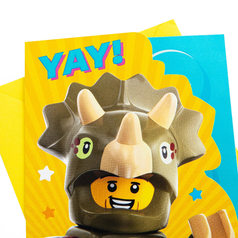 LEGO character with dinosaur helmet on a colorful background with 'YAY!' text