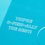 Blue card with white text 'YOU'RE O-FISH-ALLY THE BEST!' on a blue background